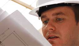 Man in a hard hat holding papers